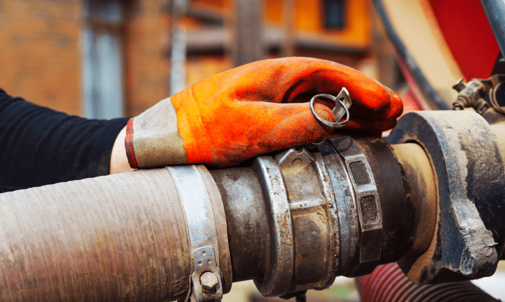 A hand in a glove holding a cleaning pipe